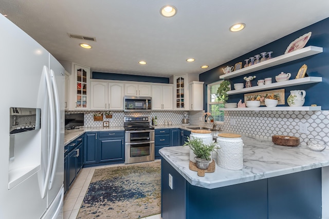 1280 Candlelite Ln, Fairborn, OH 45324 - kitchen with appliances with stainless steel finishes, blue cabinets, a sink, tasteful backsplash, and a peninsula