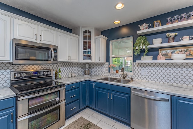 1280 Candlelite Ln, Fairborn, OH 45324 - kitchen featuring appliances with stainless steel finishes, a sink, blue cabinetry, white cabinetry, and backsplash