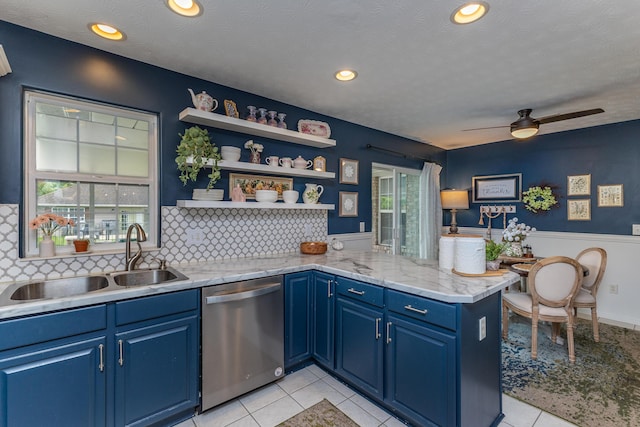 1280 Candlelite Ln, Fairborn, OH 45324 - kitchen featuring dishwasher, a sink, blue cabinetry, a peninsula, and wainscoting