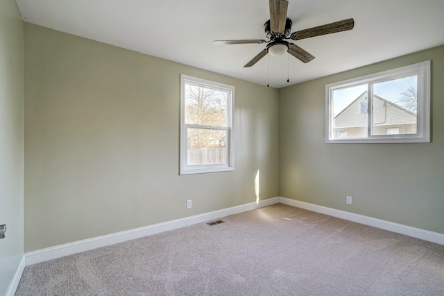 unfurnished room featuring carpet flooring, baseboards, visible vents, and plenty of natural light