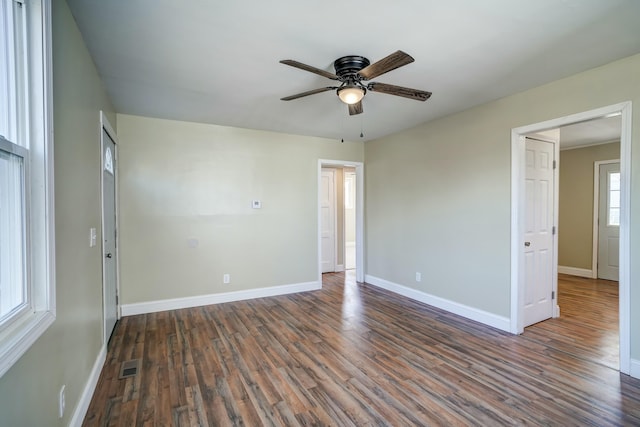 spare room featuring a ceiling fan, wood finished floors, visible vents, and baseboards