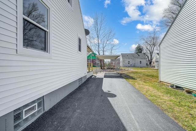 view of side of home with a yard and driveway