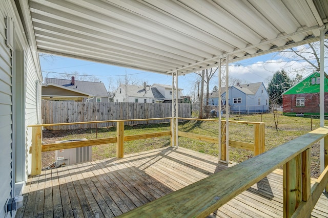 wooden deck with a residential view, a lawn, and a fenced backyard