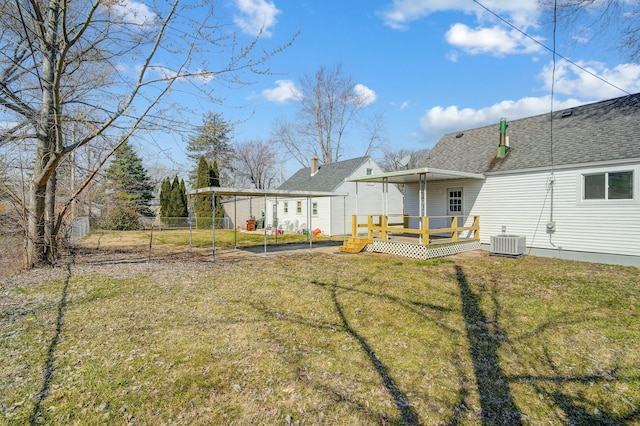 view of yard featuring a carport, central air condition unit, fence, and a wooden deck