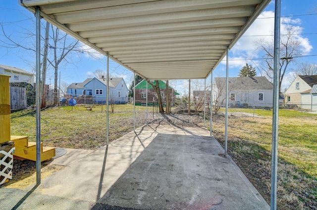 view of patio / terrace with a carport, a fenced backyard, and a residential view