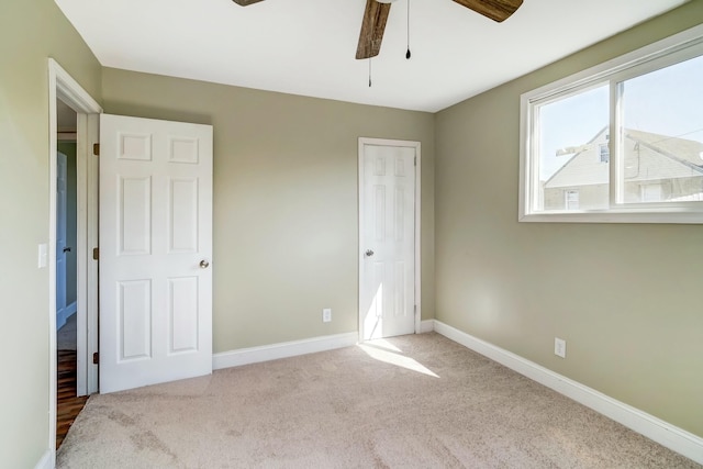 unfurnished bedroom featuring carpet flooring, a ceiling fan, and baseboards