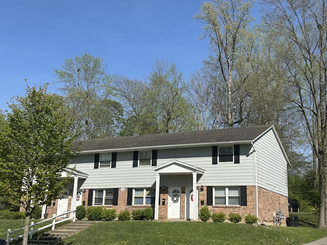 view of front of property featuring a front yard and brick siding