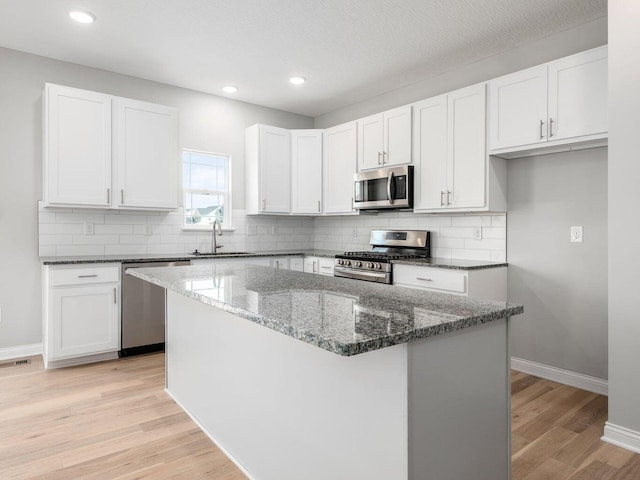 kitchen with stainless steel appliances, a center island, and white cabinets