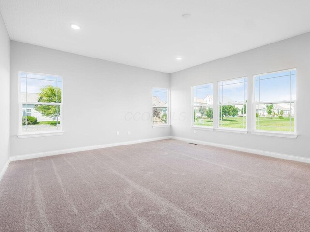 spare room featuring carpet floors, recessed lighting, and baseboards