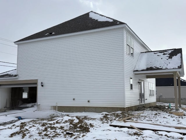 snow covered property with a garage