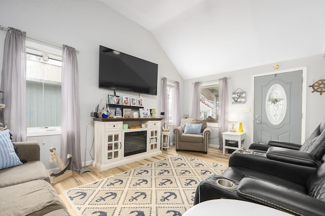 living area featuring baseboards, vaulted ceiling, and wood finished floors