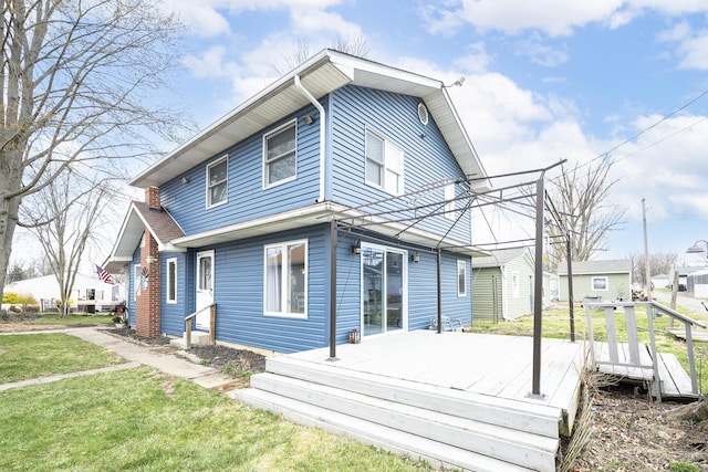 rear view of property featuring a wooden deck and a yard