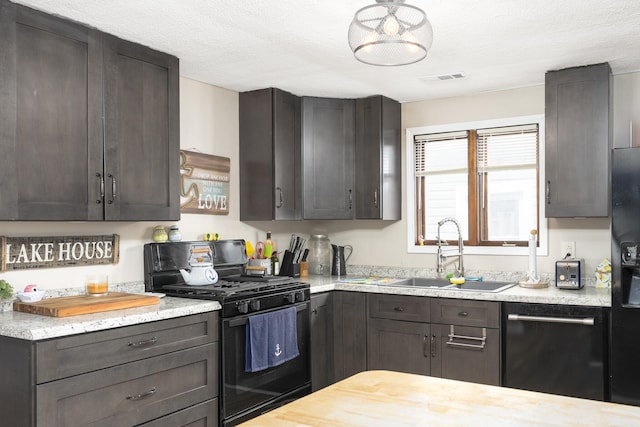 kitchen featuring gas stove, a sink, visible vents, dishwashing machine, and dark brown cabinetry