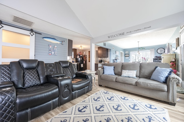 living room with light wood-style flooring, high vaulted ceiling, and visible vents