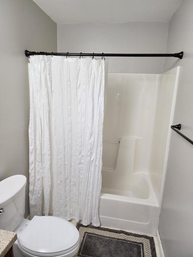 full bath with tile patterned floors, toilet, and shower / bath combo