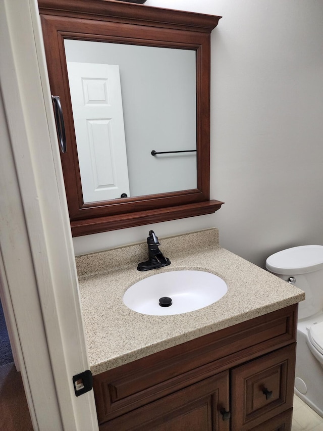 half bathroom with vanity and toilet