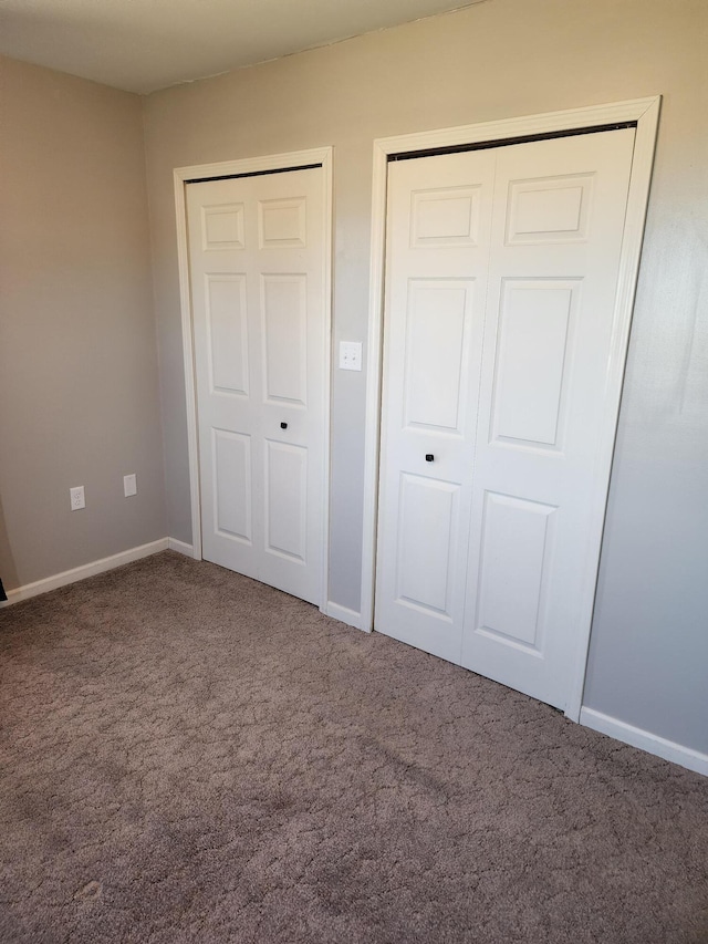 unfurnished bedroom with a closet, baseboards, and carpet floors