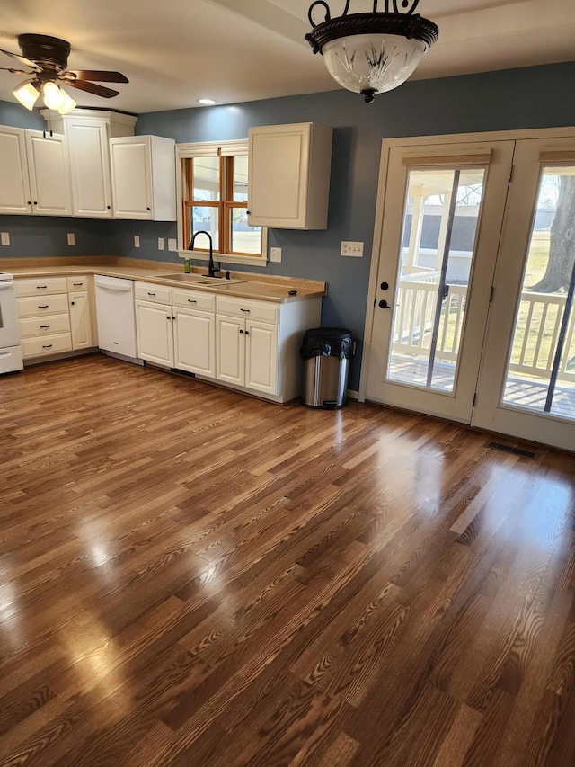 kitchen featuring a sink, white appliances, white cabinets, and dark wood finished floors