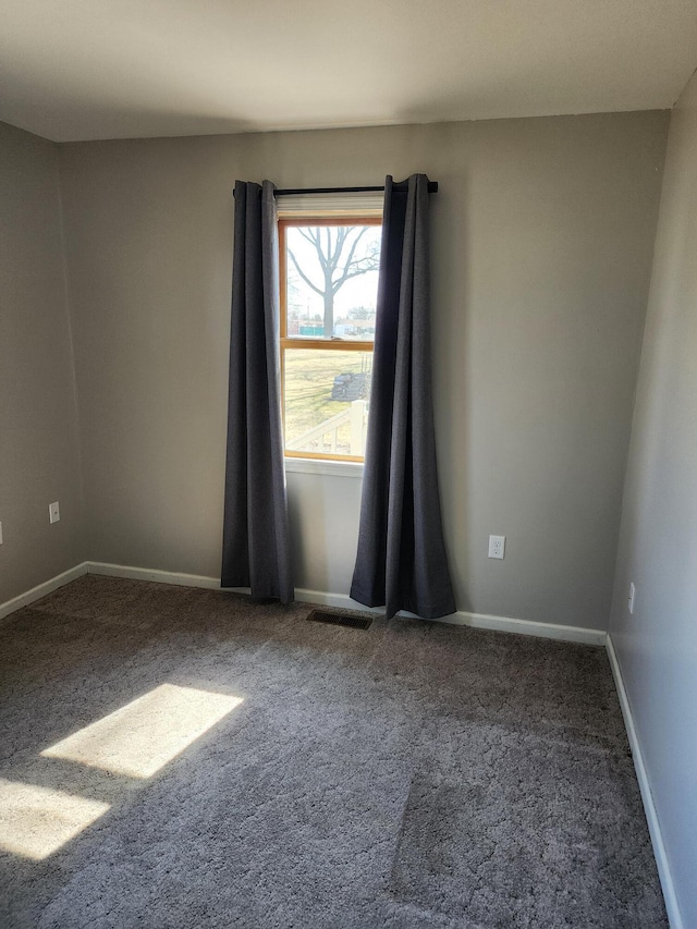 unfurnished room featuring carpet flooring, visible vents, and baseboards