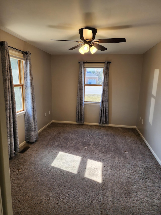 spare room with visible vents, baseboards, a ceiling fan, and carpet flooring