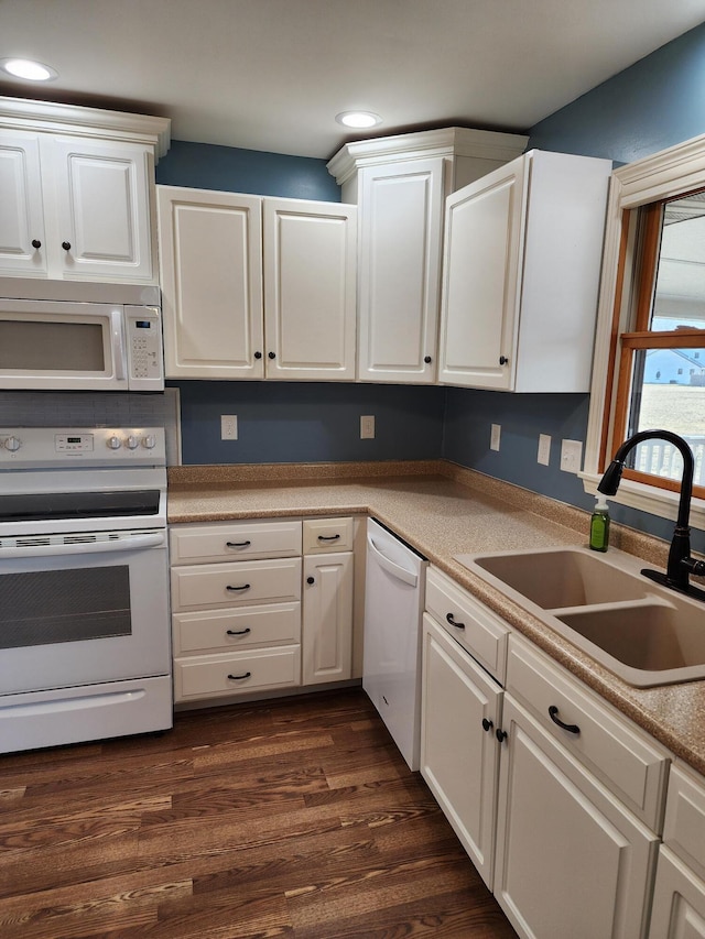 kitchen featuring a sink, white appliances, and white cabinets