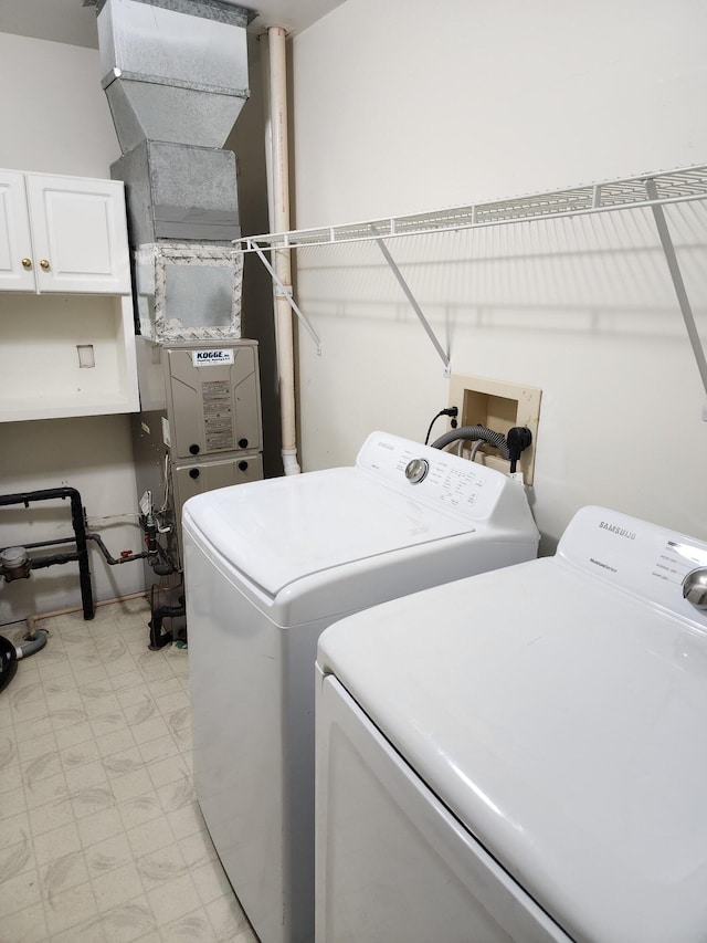 washroom with cabinet space, marble finish floor, and washer and clothes dryer