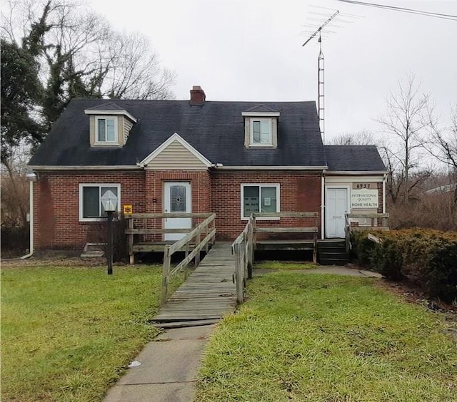 6937 N Main St, Dayton, OH 45415 - view of front of house with brick siding, a chimney, a front lawn, and a wooden deck