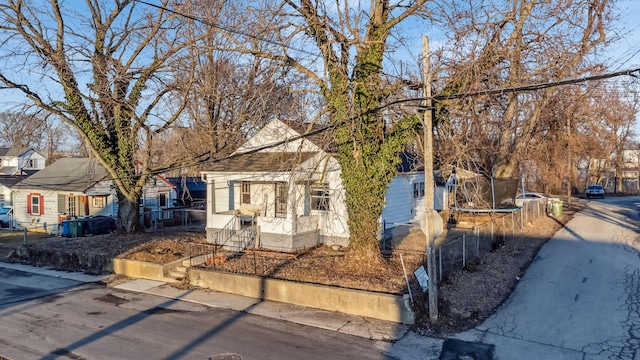 view of front facade featuring a residential view, a trampoline, and fence