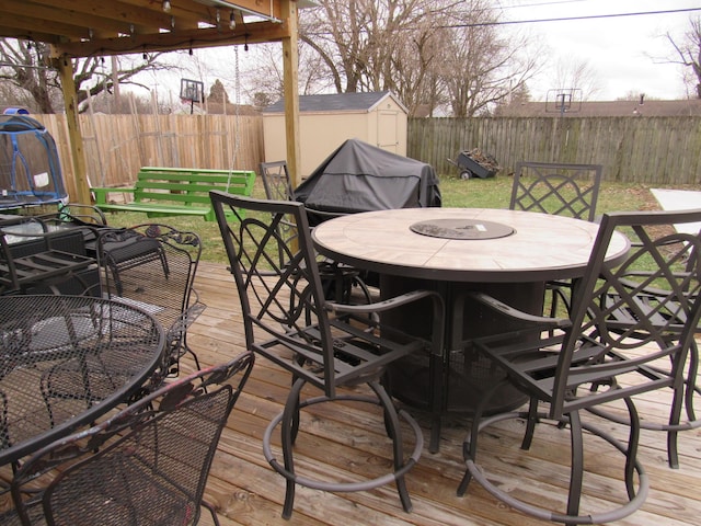 deck featuring a trampoline and a storage shed