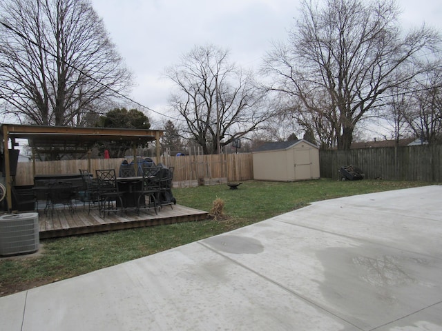 view of yard with a wooden deck, a patio, central AC unit, and a storage unit