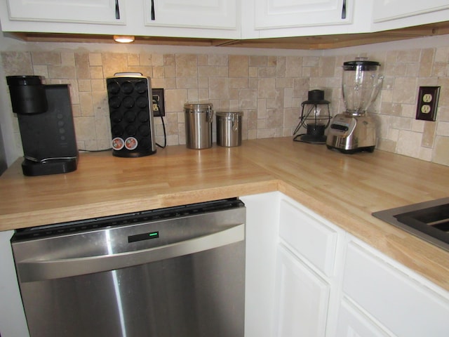 kitchen featuring stainless steel dishwasher, white cabinets, and backsplash