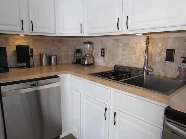 kitchen featuring butcher block counters, sink, white cabinetry, stainless steel dishwasher, and decorative backsplash