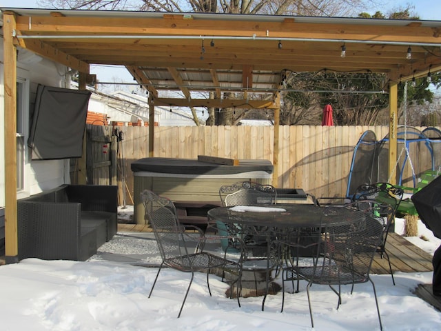 snow covered patio with a hot tub