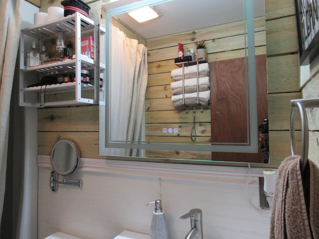 bathroom featuring wooden walls