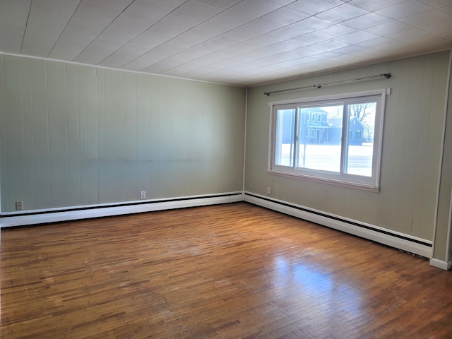 spare room with hardwood / wood-style flooring and baseboard heating