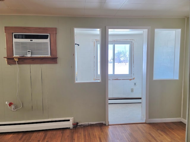 doorway to outside with hardwood / wood-style flooring, a baseboard radiator, and a wall mounted AC