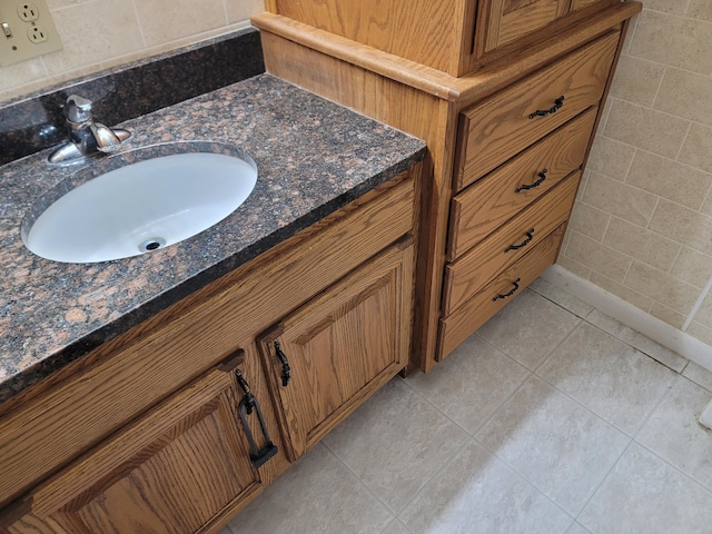 bathroom featuring tile patterned flooring, vanity, and tile walls