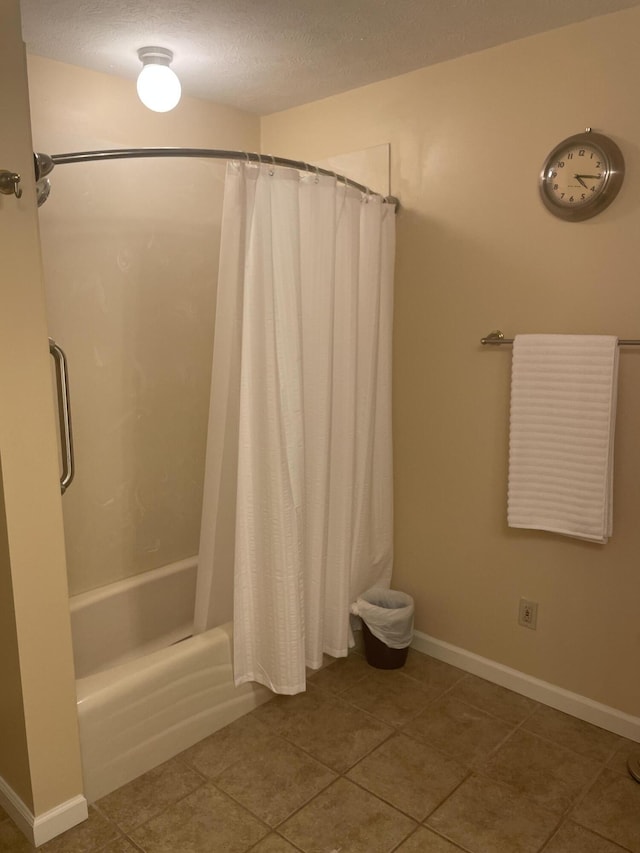 full bathroom with baseboards, tile patterned flooring, a textured ceiling, and shower / bath combination with curtain