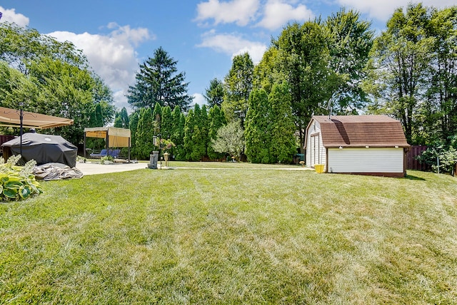 view of yard featuring a storage unit, an outdoor structure, fence, and a patio
