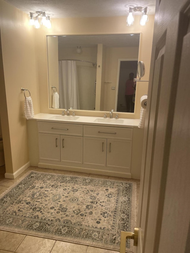 full bathroom featuring a sink, tile patterned flooring, double vanity, and a shower with shower curtain