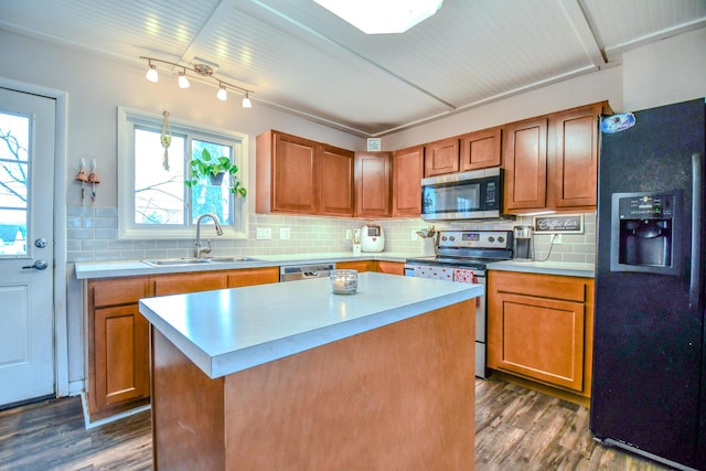 kitchen featuring sink, stainless steel appliances, dark hardwood / wood-style floors, tasteful backsplash, and a kitchen island