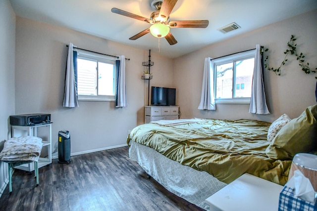 bedroom with dark hardwood / wood-style flooring, multiple windows, and ceiling fan