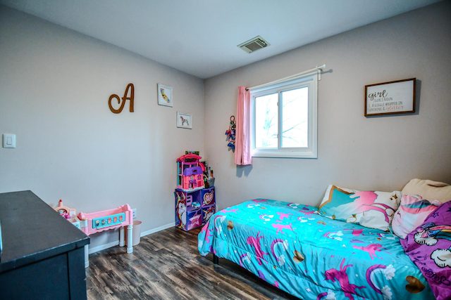 bedroom with dark wood-type flooring