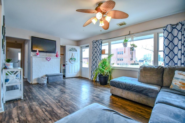 living room featuring ceiling fan and dark hardwood / wood-style flooring