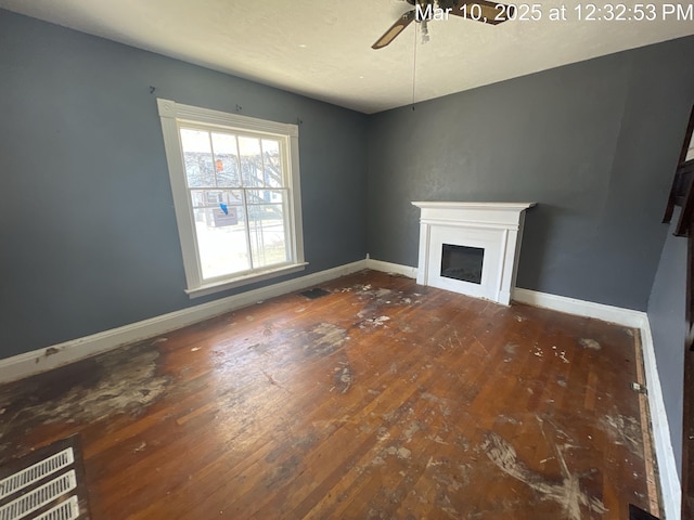 unfurnished living room featuring a fireplace, baseboards, wood-type flooring, and ceiling fan