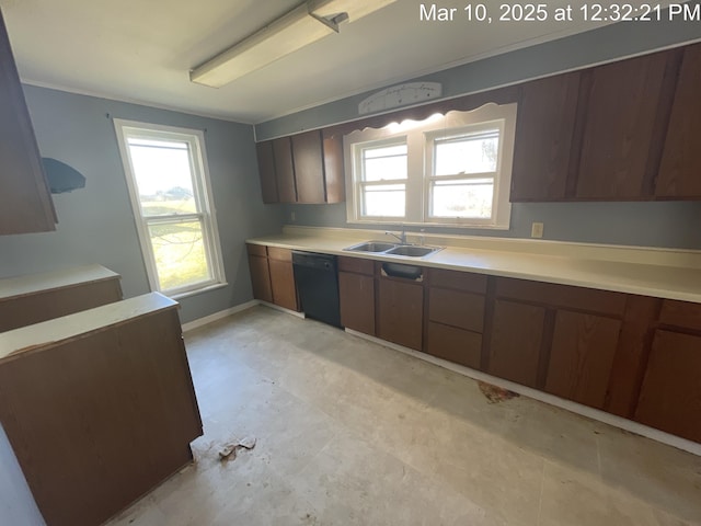 kitchen featuring a sink, black dishwasher, light countertops, baseboards, and light floors