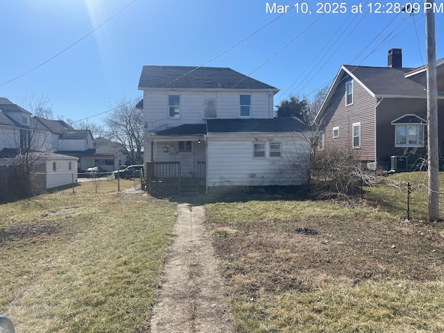 back of house with a lawn and fence