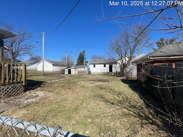 view of yard featuring an outbuilding and fence