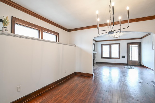 foyer entrance featuring dark wood-style floors, crown molding, a notable chandelier, and baseboards