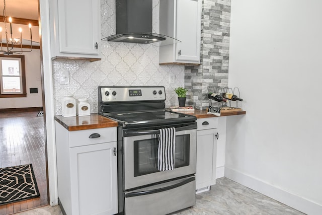 kitchen featuring white cabinetry, wooden counters, electric range, and wall chimney exhaust hood